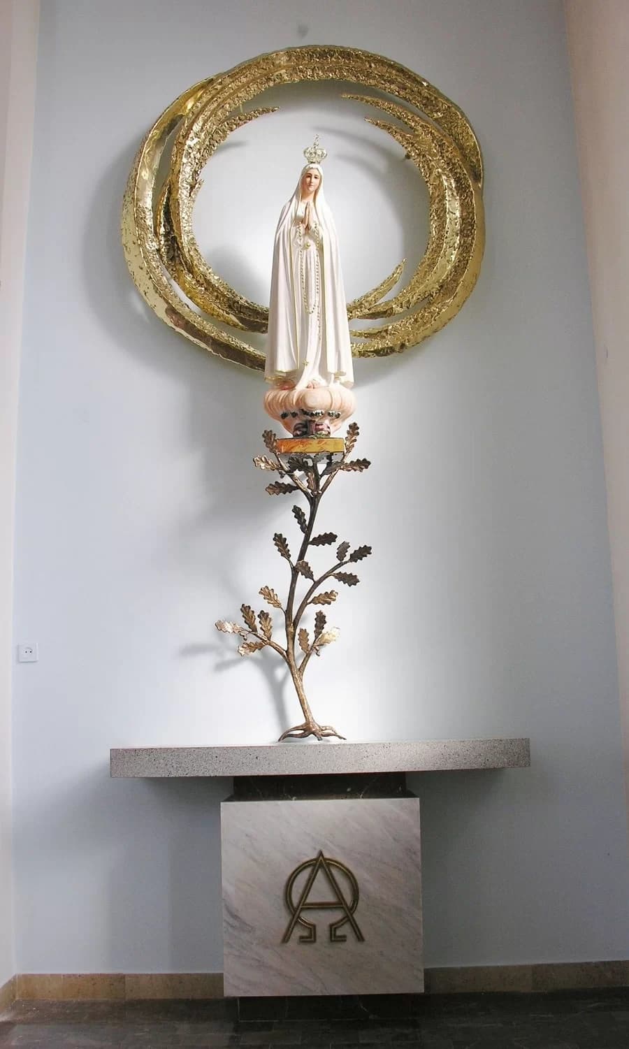 Figura Matki Bożej Fatimskiej w złoconej metalowej oprawie na drewnianym cokole