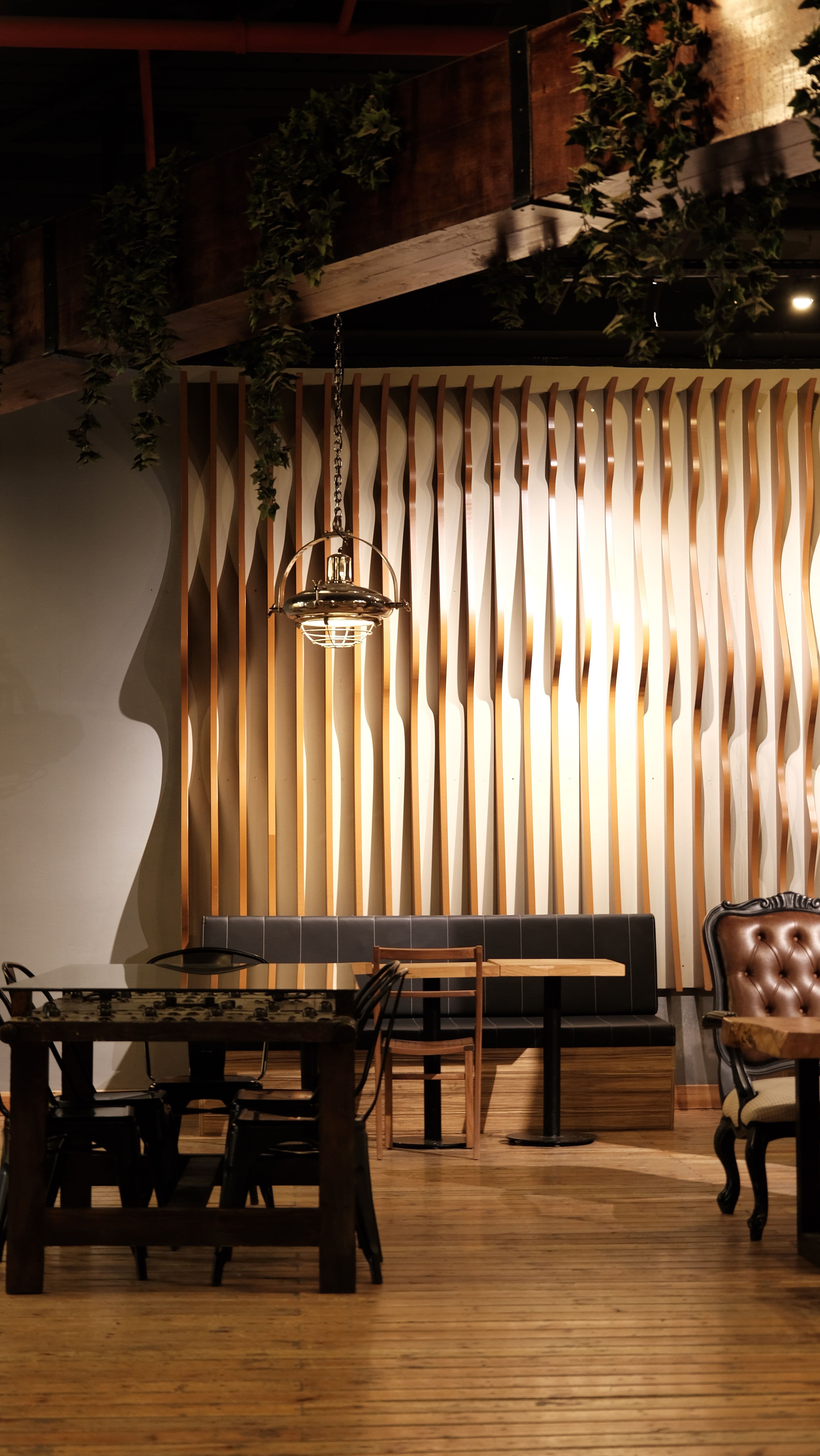 Faliste drewniane lamele parametryczne na ścianie wnętrza restauracji